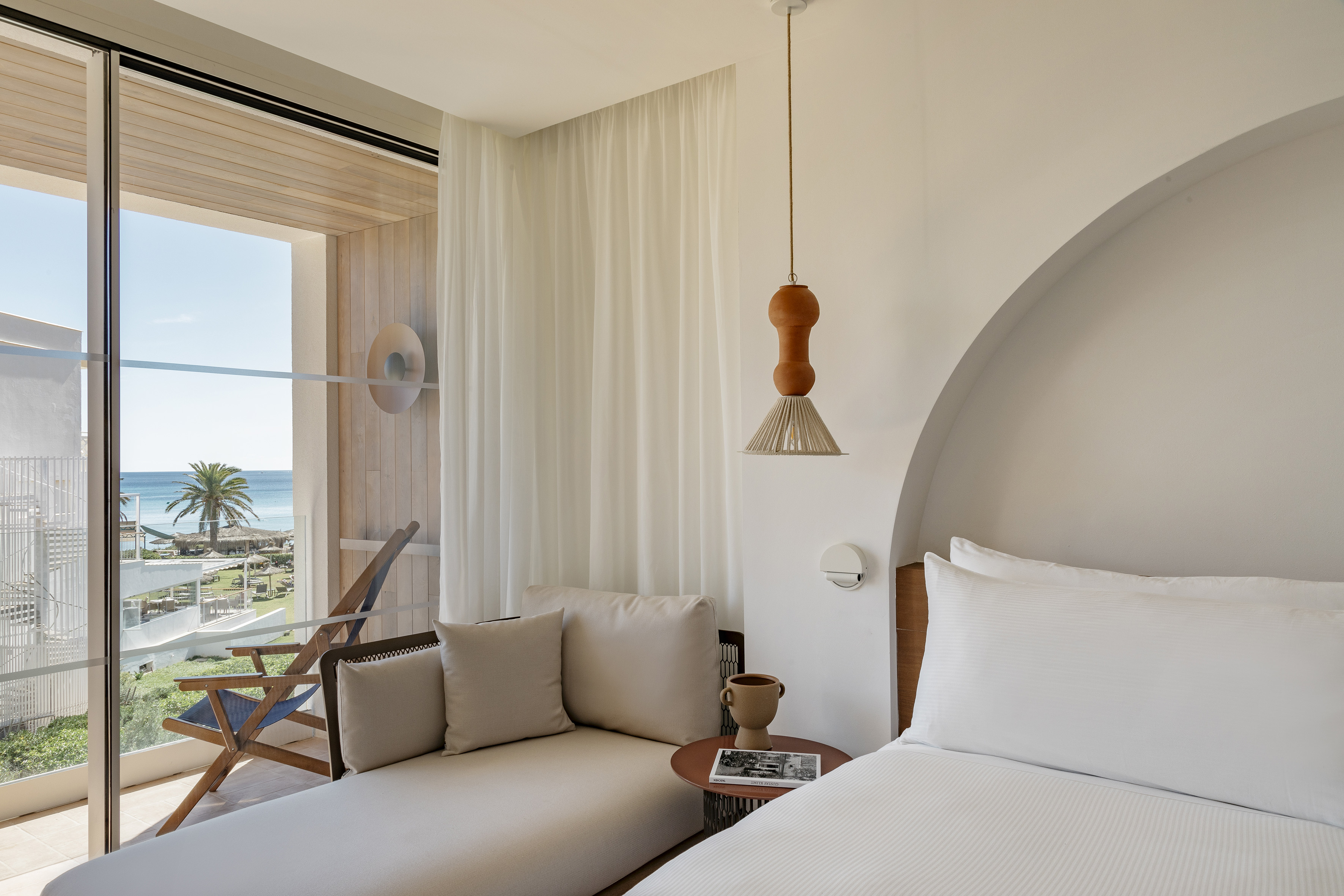 Coastal hotel room with ocean view, private balcony, and comfortable daybed.