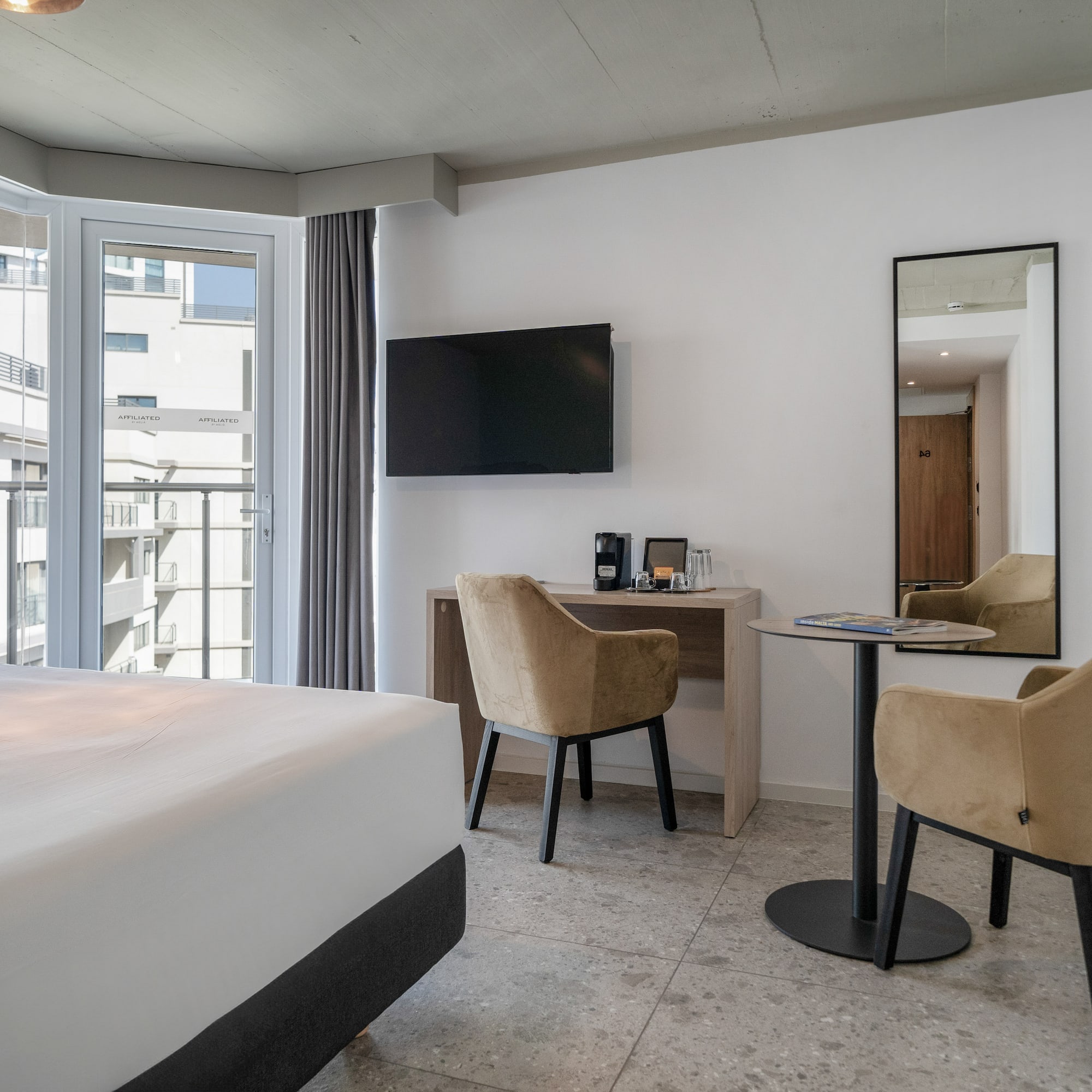 a room with a bed and a table and chairs