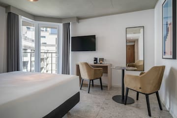 a room with a bed and a table and chairs