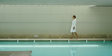 a woman walking near a pool