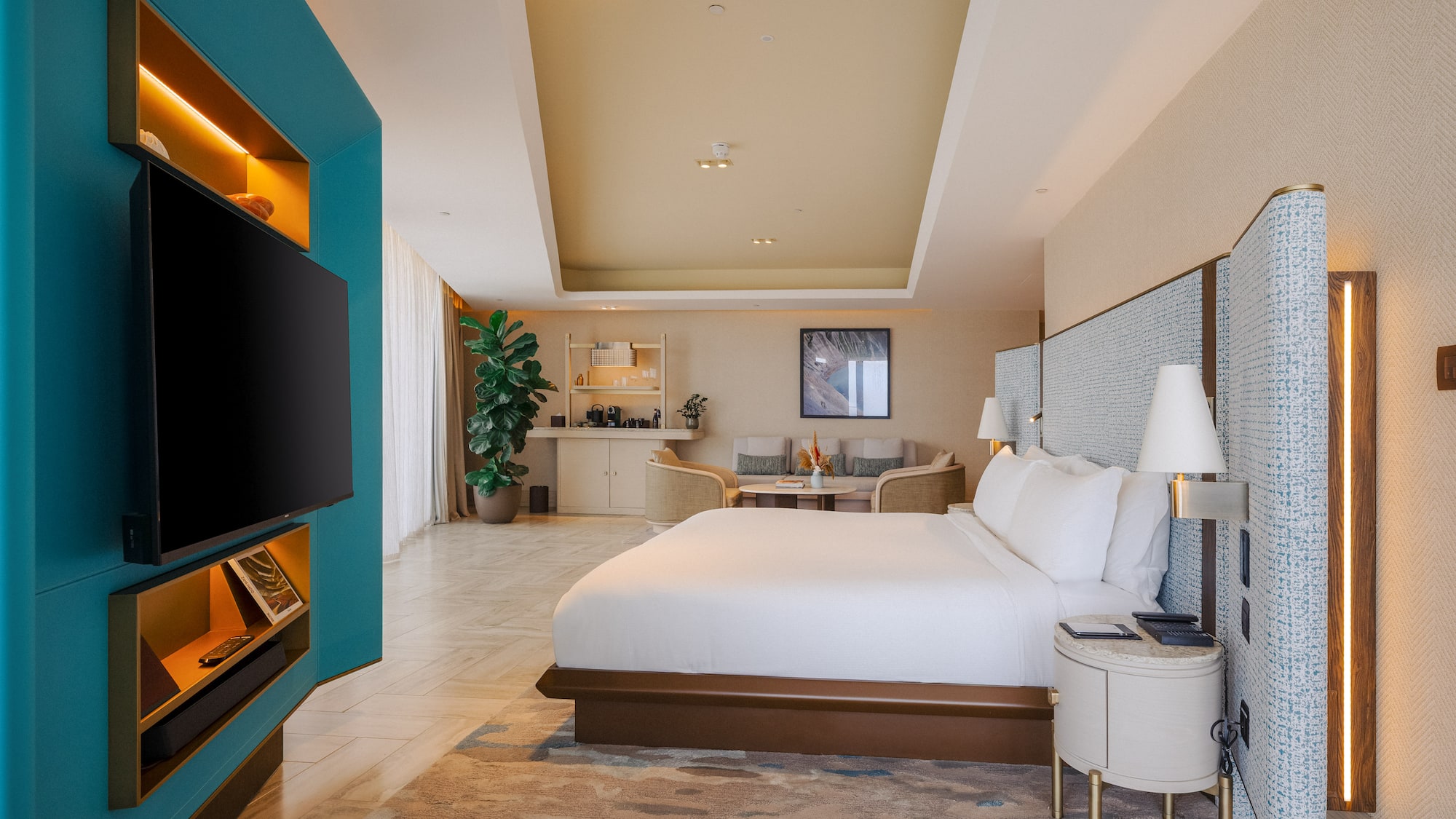 Luxury hotel suite bedroom with modern design, teal wall, king bed, and lounge.