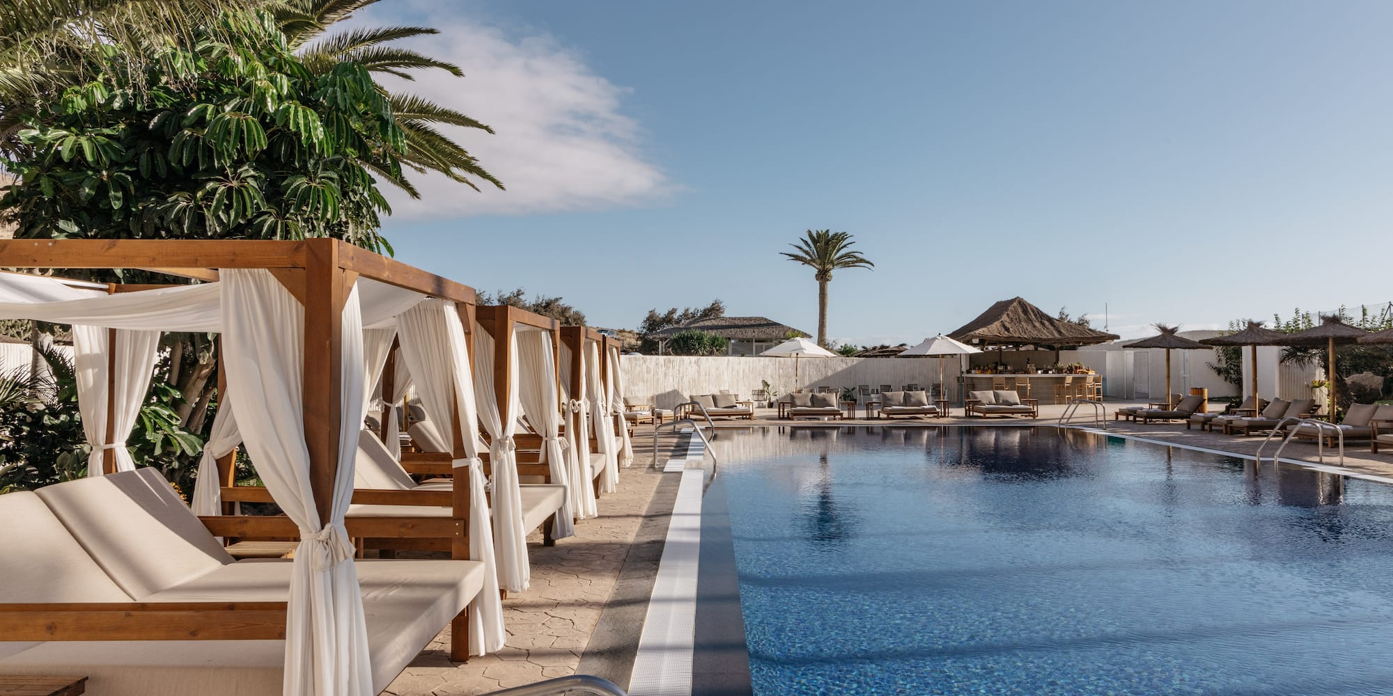 a pool with lounge chairs and umbrellas
