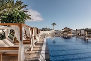 a pool with lounge chairs and umbrellas