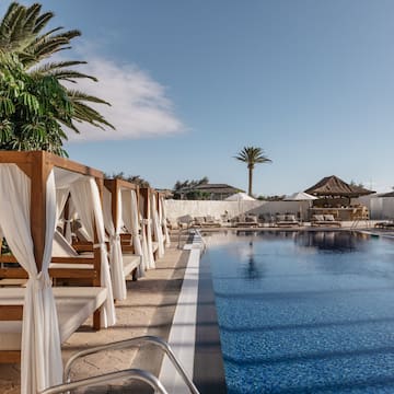 a pool with lounge chairs and umbrellas