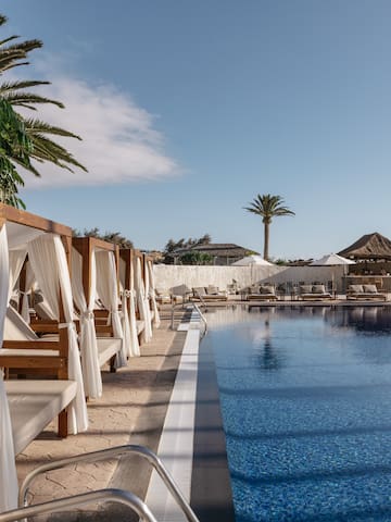 a pool with lounge chairs and umbrellas
