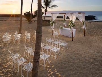 a beach setting with chairs and a table