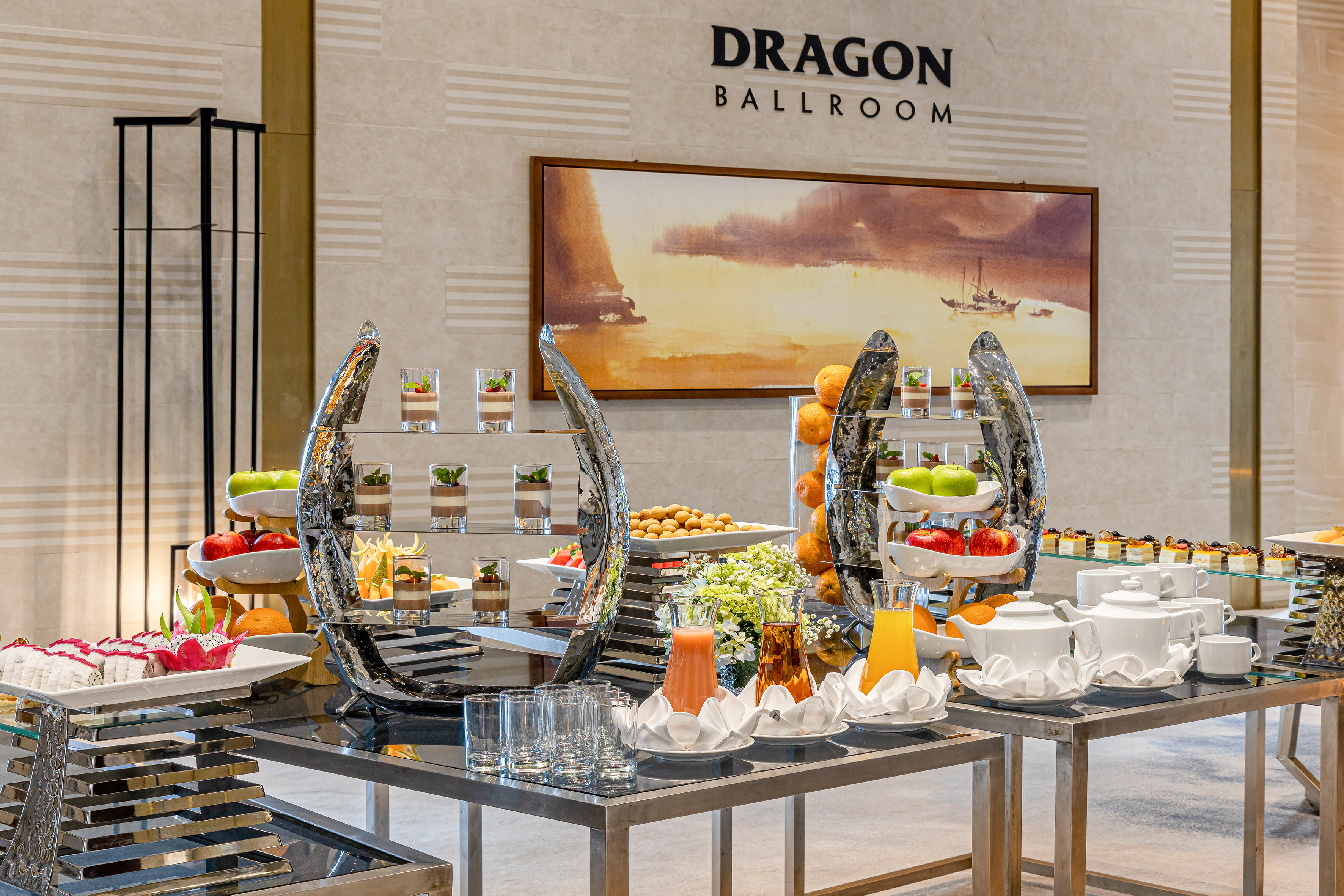 Elegant hotel buffet in Dragon Ballroom featuring desserts, fresh fruit, and juices.