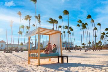 a couple sitting on a bed on a beach