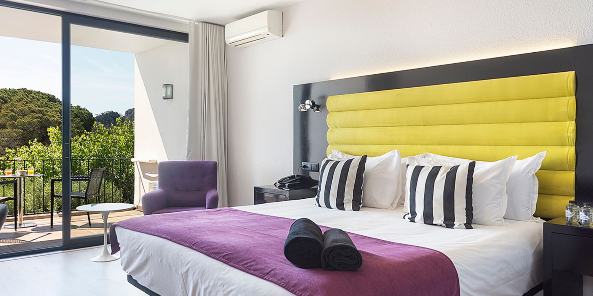 a bedroom with a purple and yellow bed and purple chair