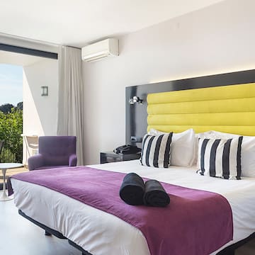 a bedroom with a purple and yellow bed and purple chair