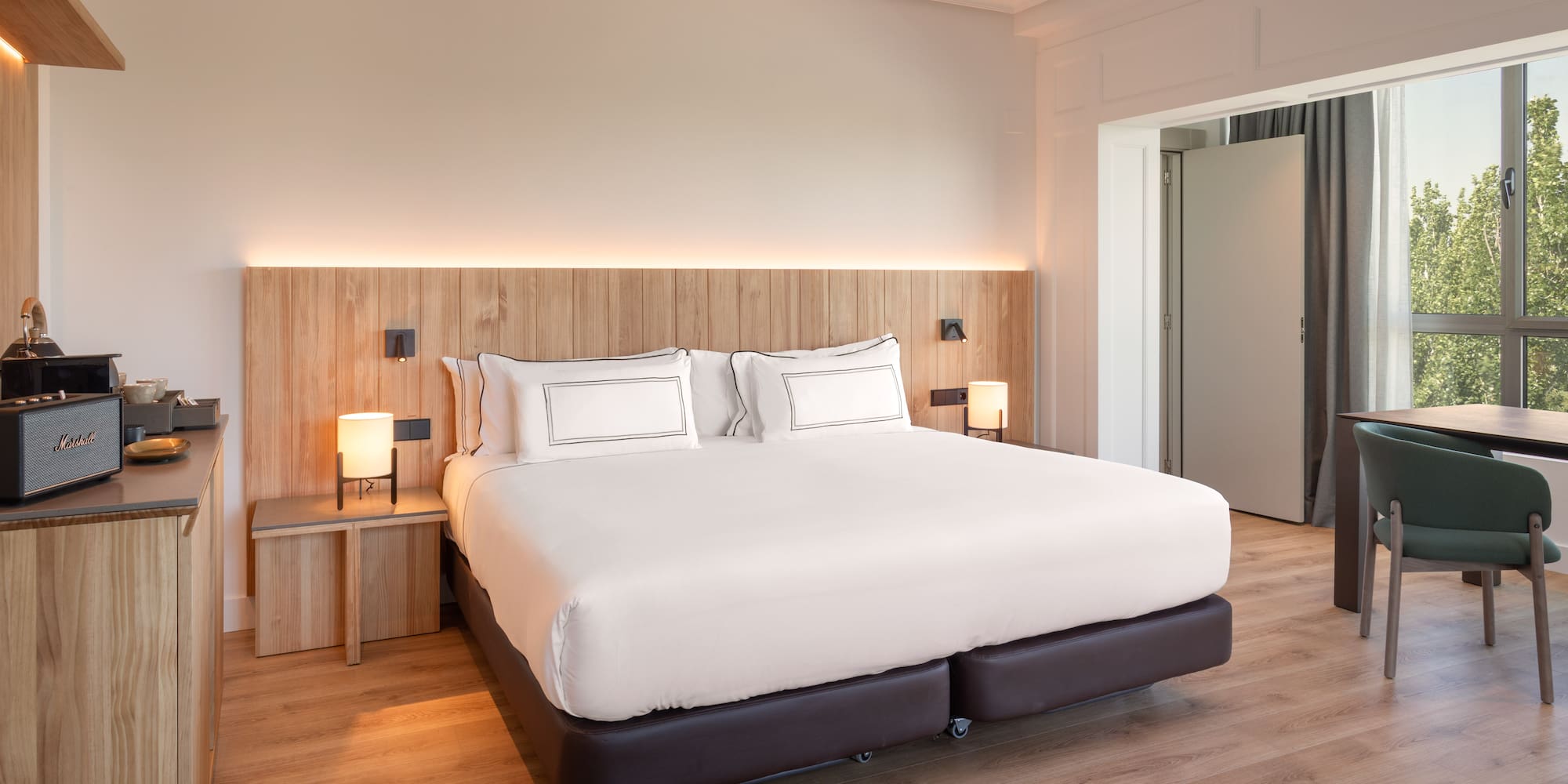 a bed with white sheets and a wood floor