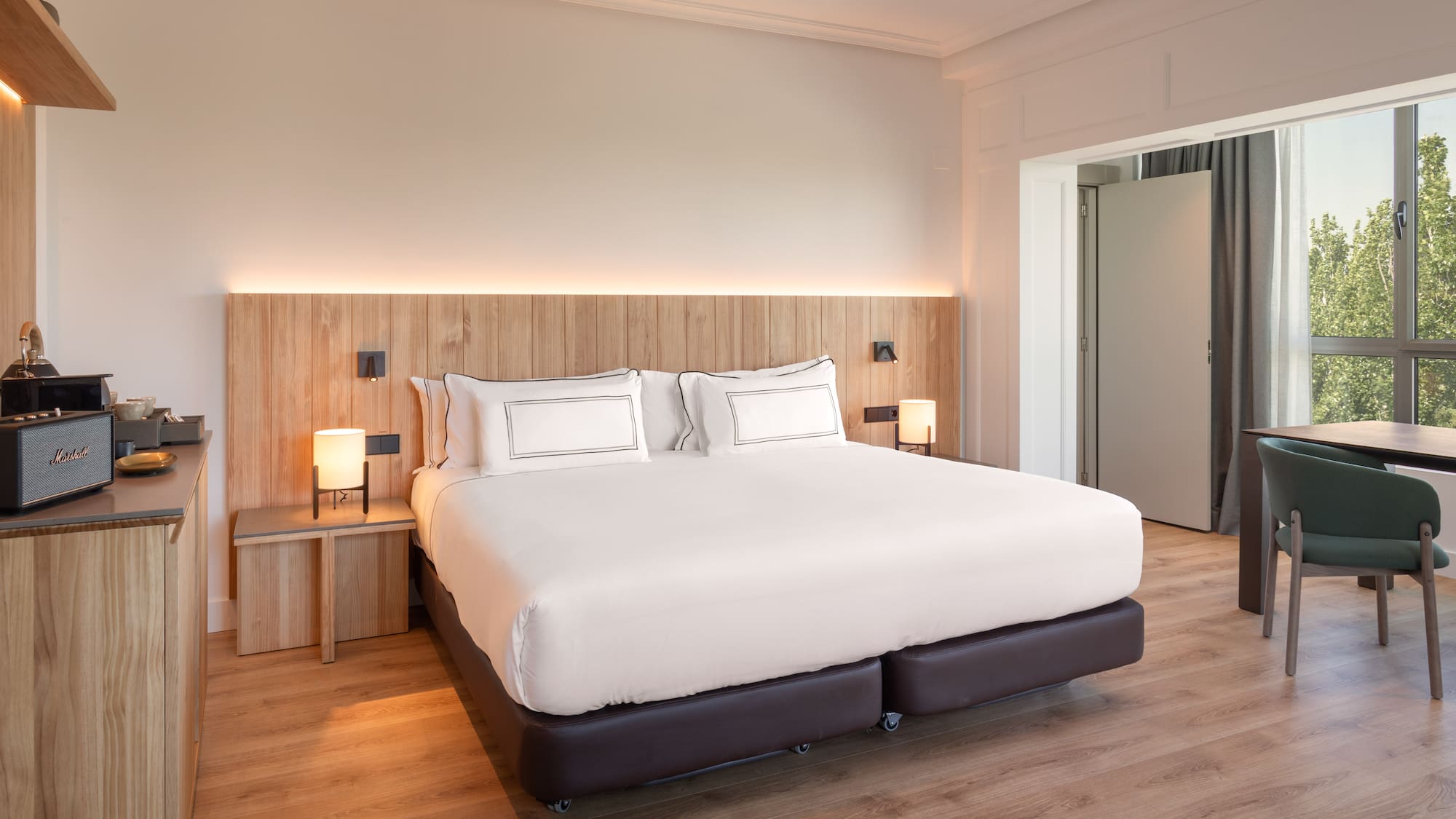 a bed with white sheets and a wood floor