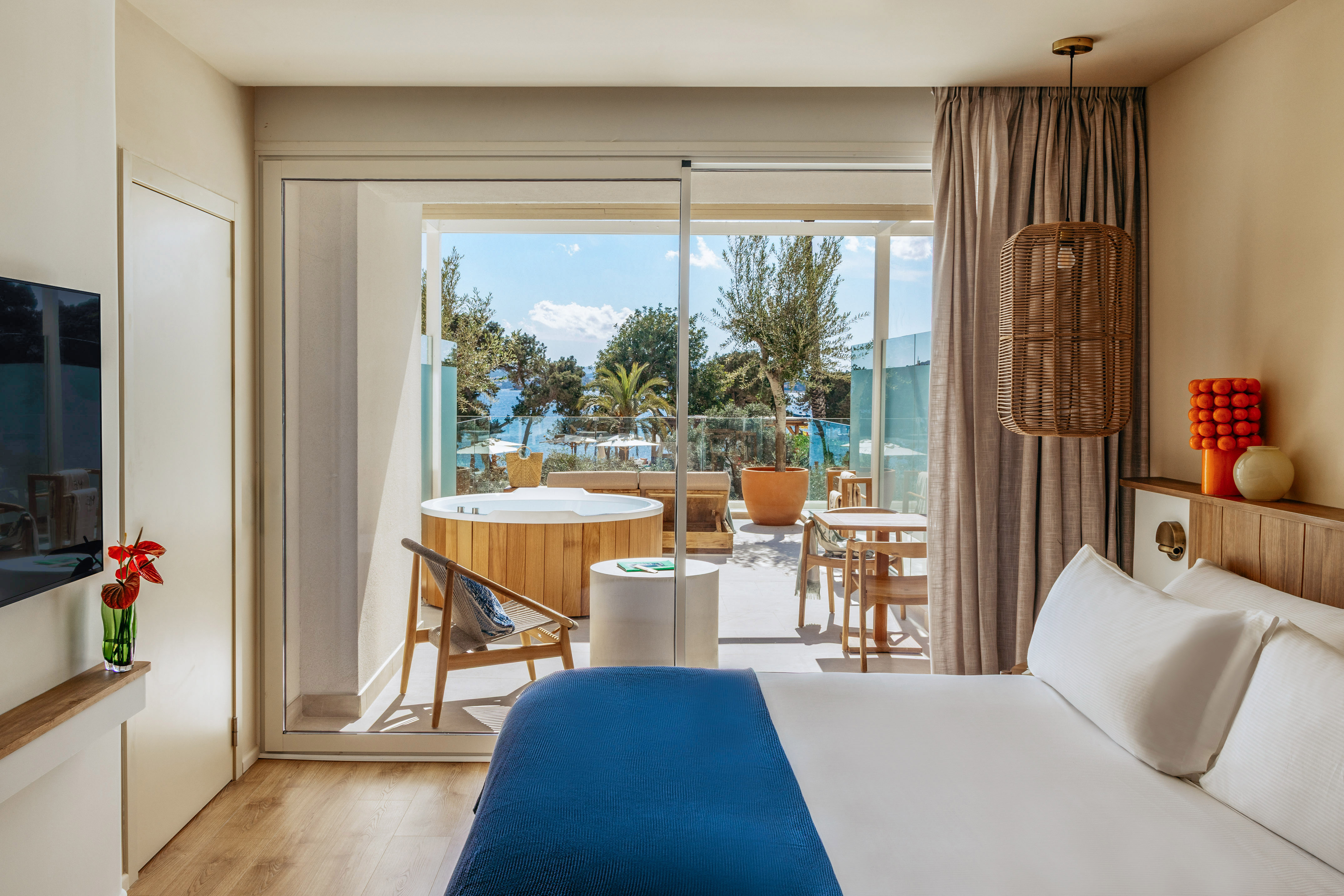 Luxury hotel bedroom with private hot tub balcony and sea view.