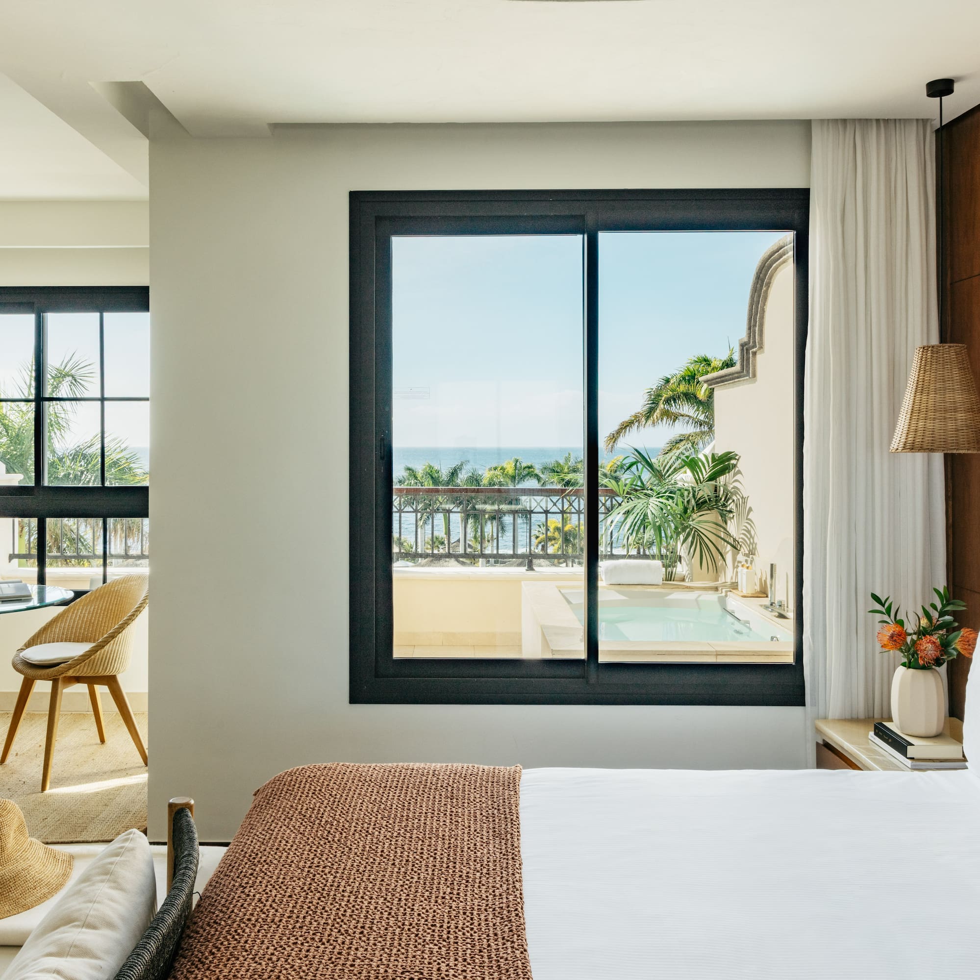 a bedroom with a view of the ocean and a glass door