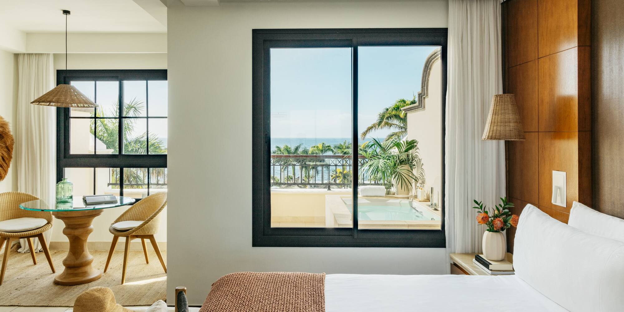 a bedroom with a view of the ocean and a glass door