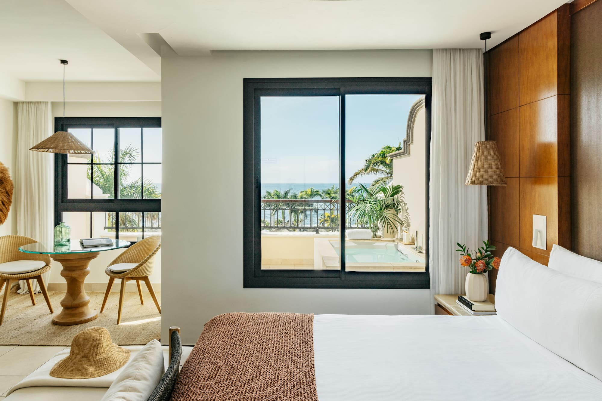 a bedroom with a view of the ocean and a glass door