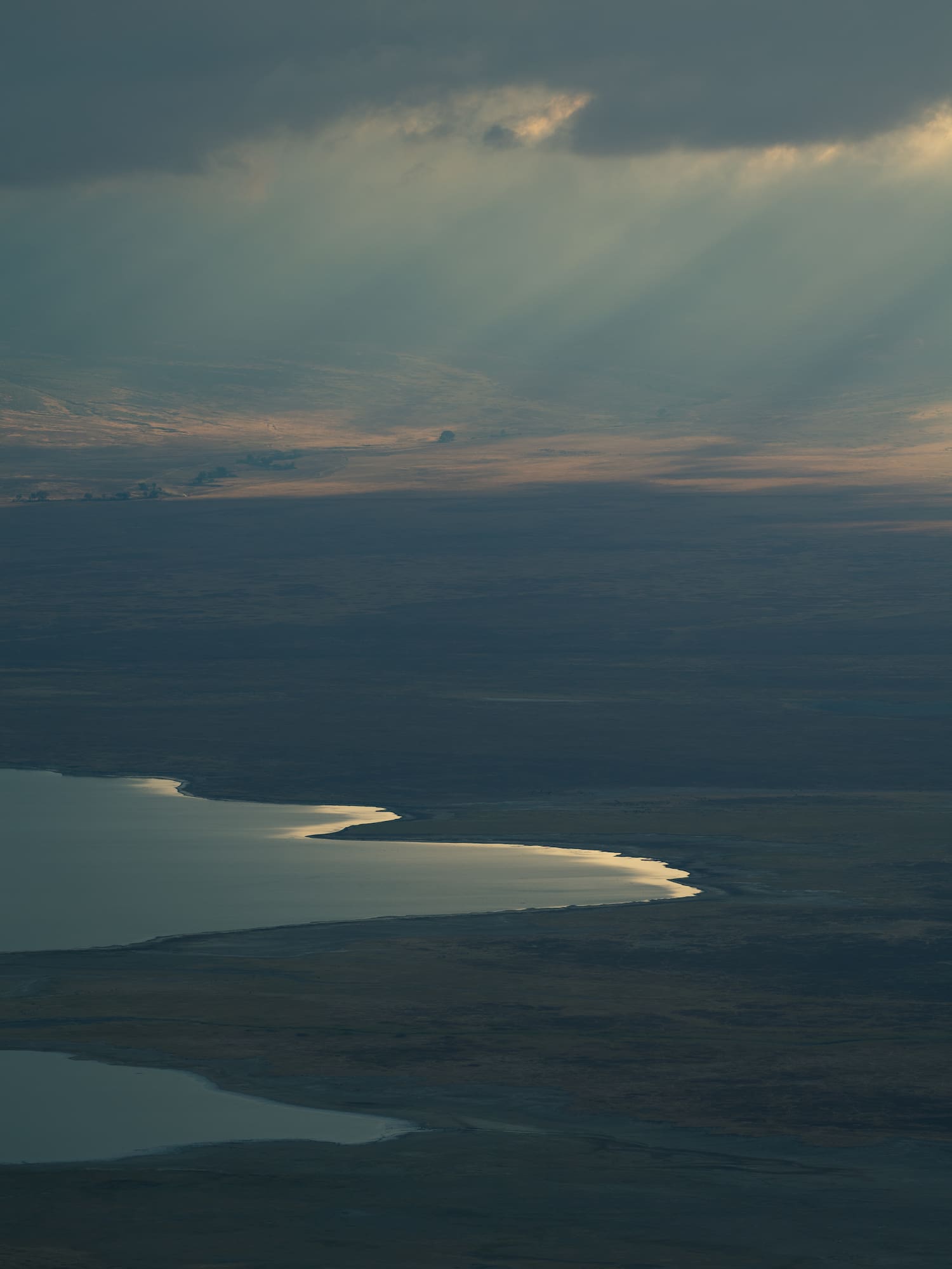 a landscape with a lake and sun rays