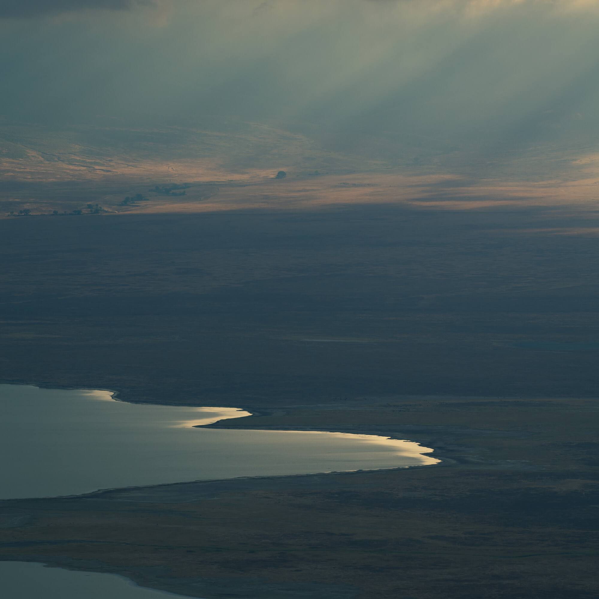 a landscape with a lake and sun rays