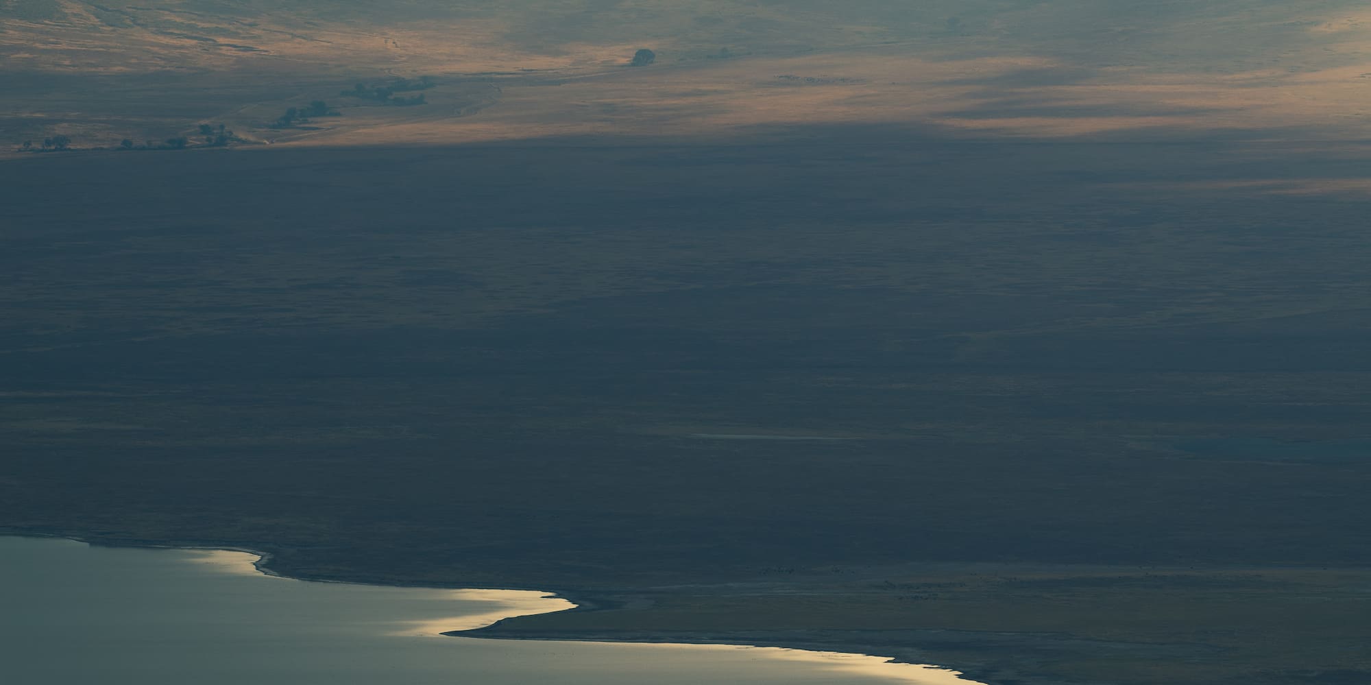 a landscape with a lake and sun rays