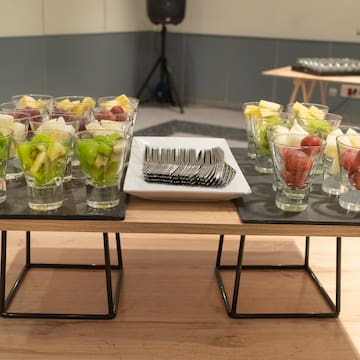 a table with glasses of fruit and forks