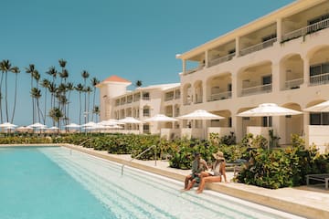 a man and woman sitting on a pool side