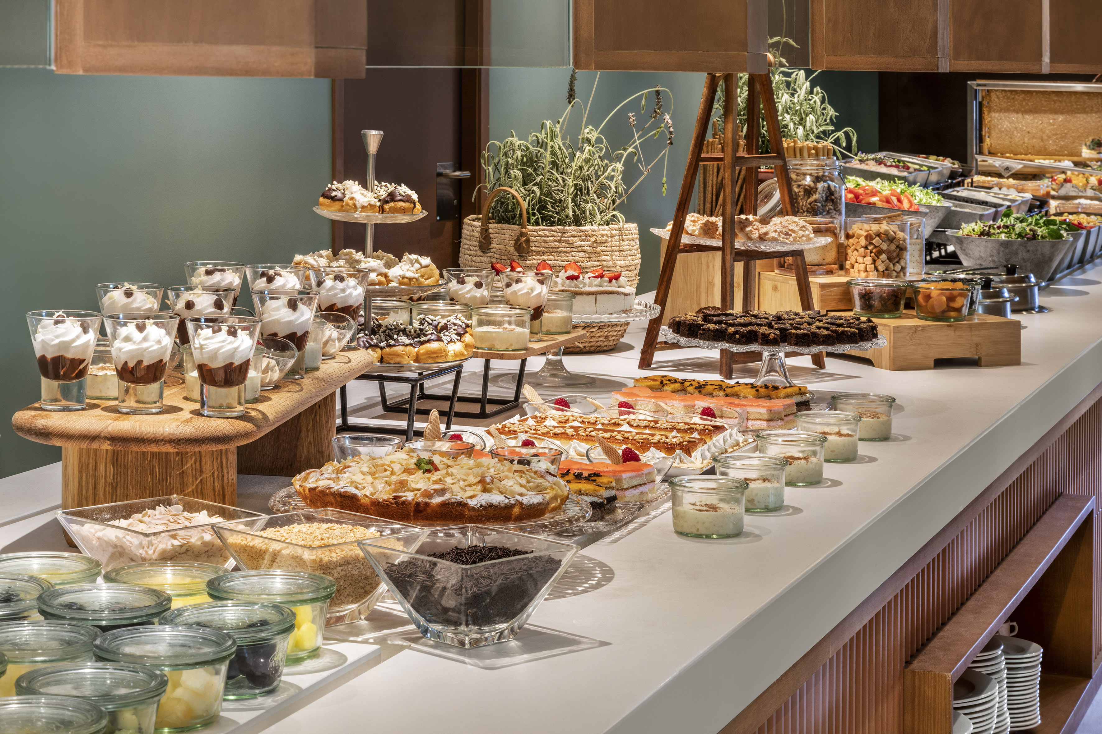 Abundant dessert buffet with cakes, parfaits, brownies, and breakfast cereals.