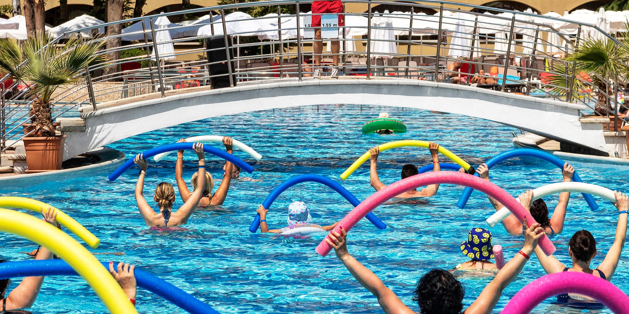 a group of people in a pool with noodle