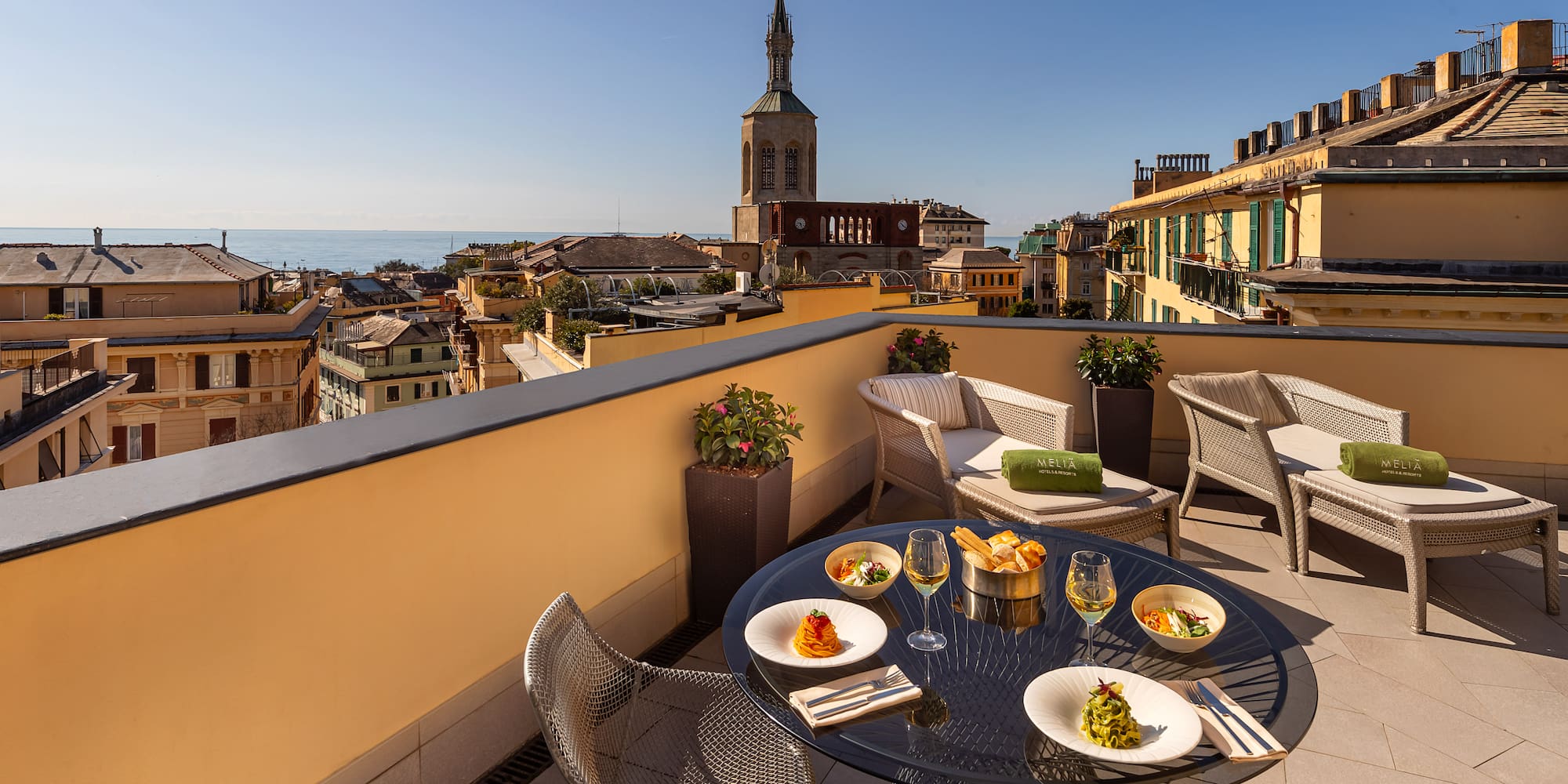 a table and chairs on a balcony overlooking a city