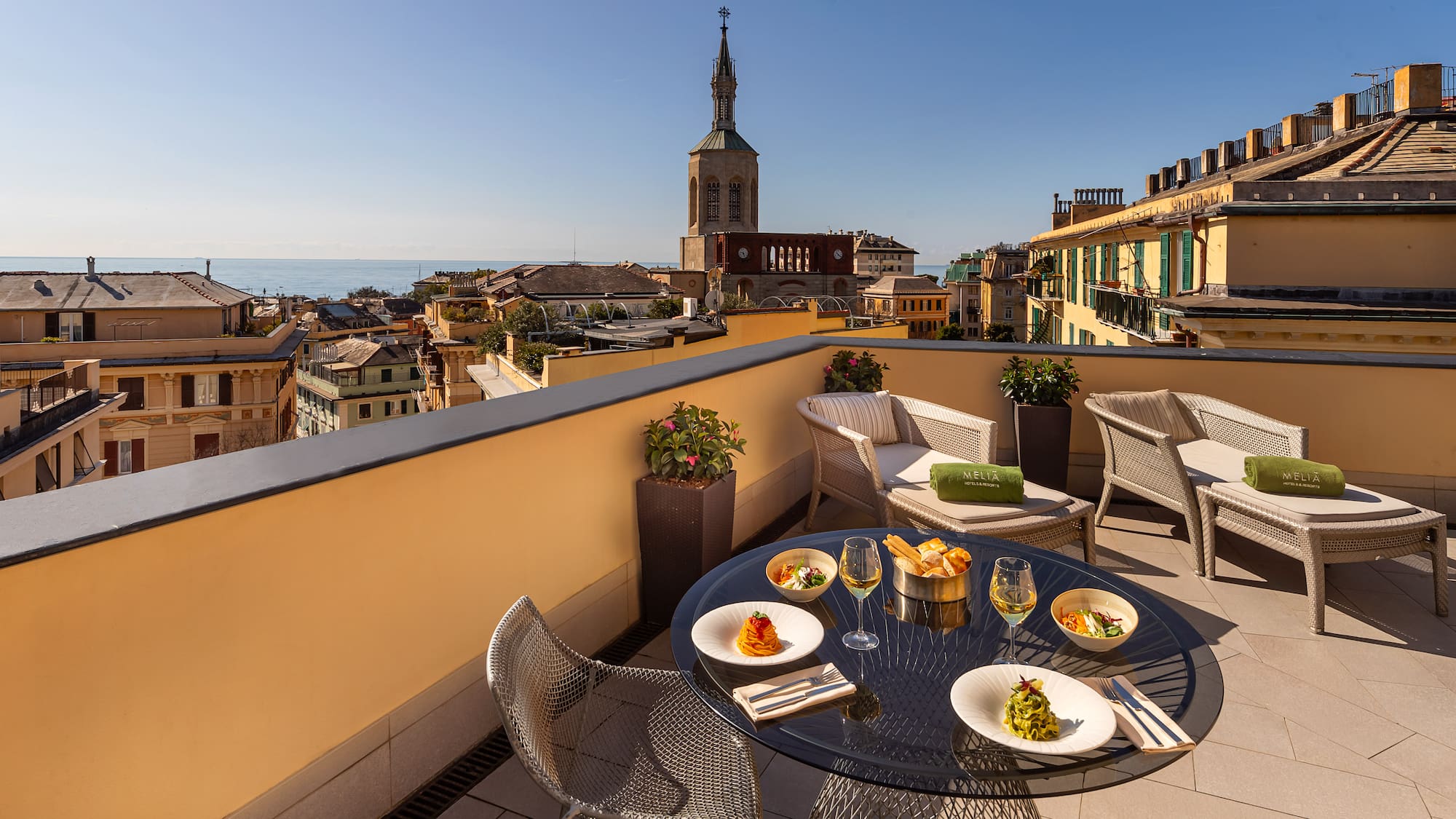 a table and chairs on a balcony overlooking a city