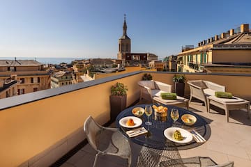 a table and chairs on a balcony overlooking a city