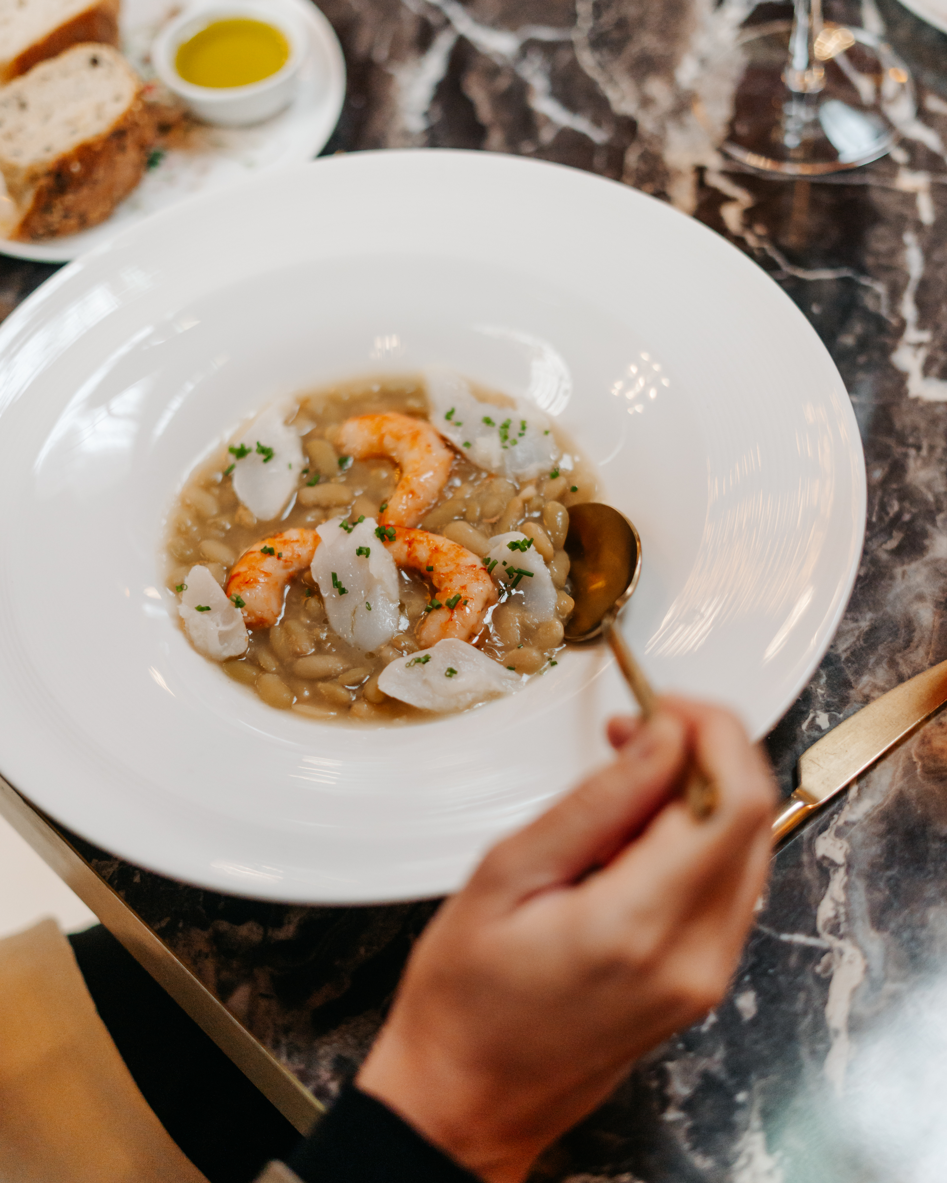 a person holding a spoon in a bowl of food