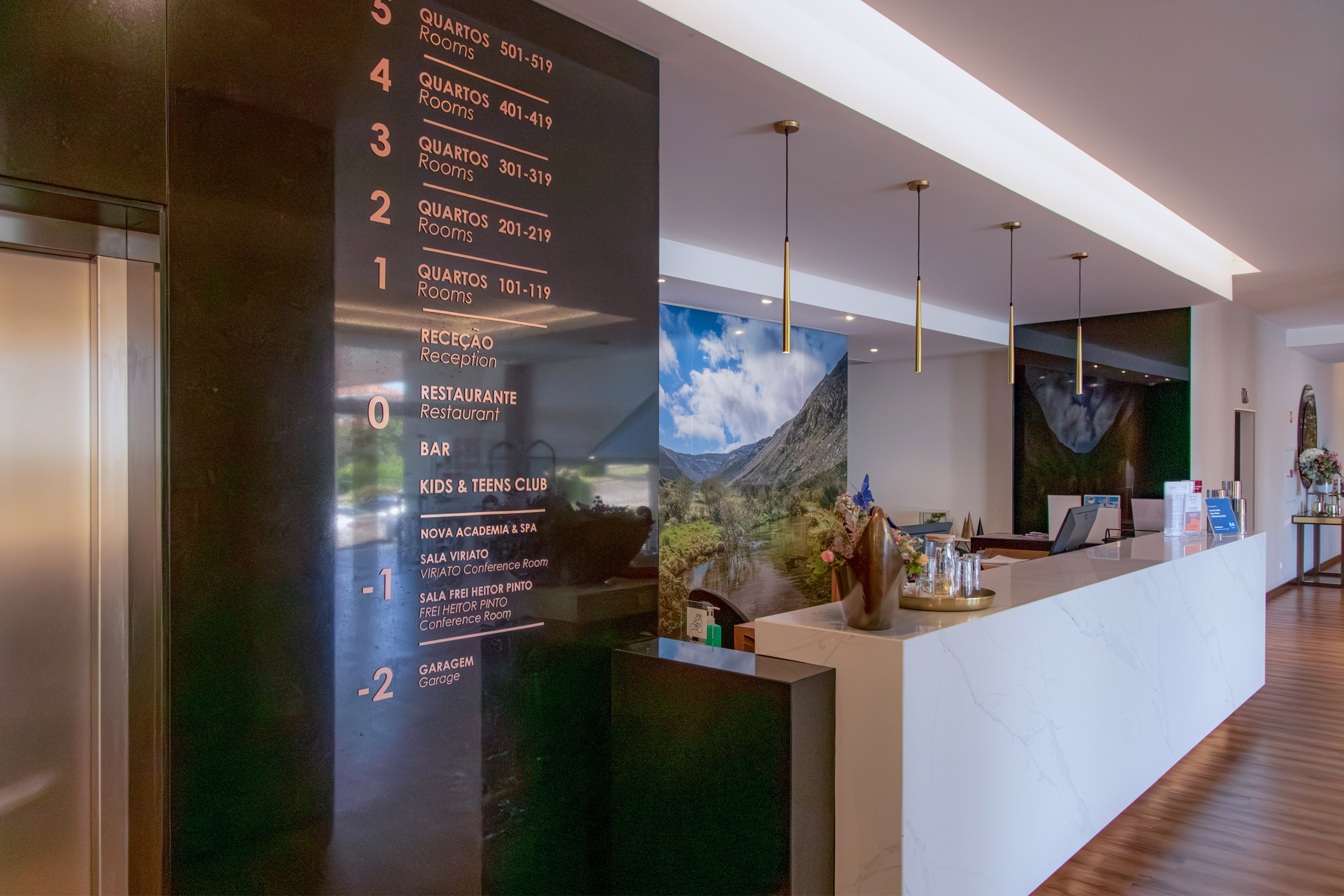 Hotel reception area with floor directory and modern marble desk.