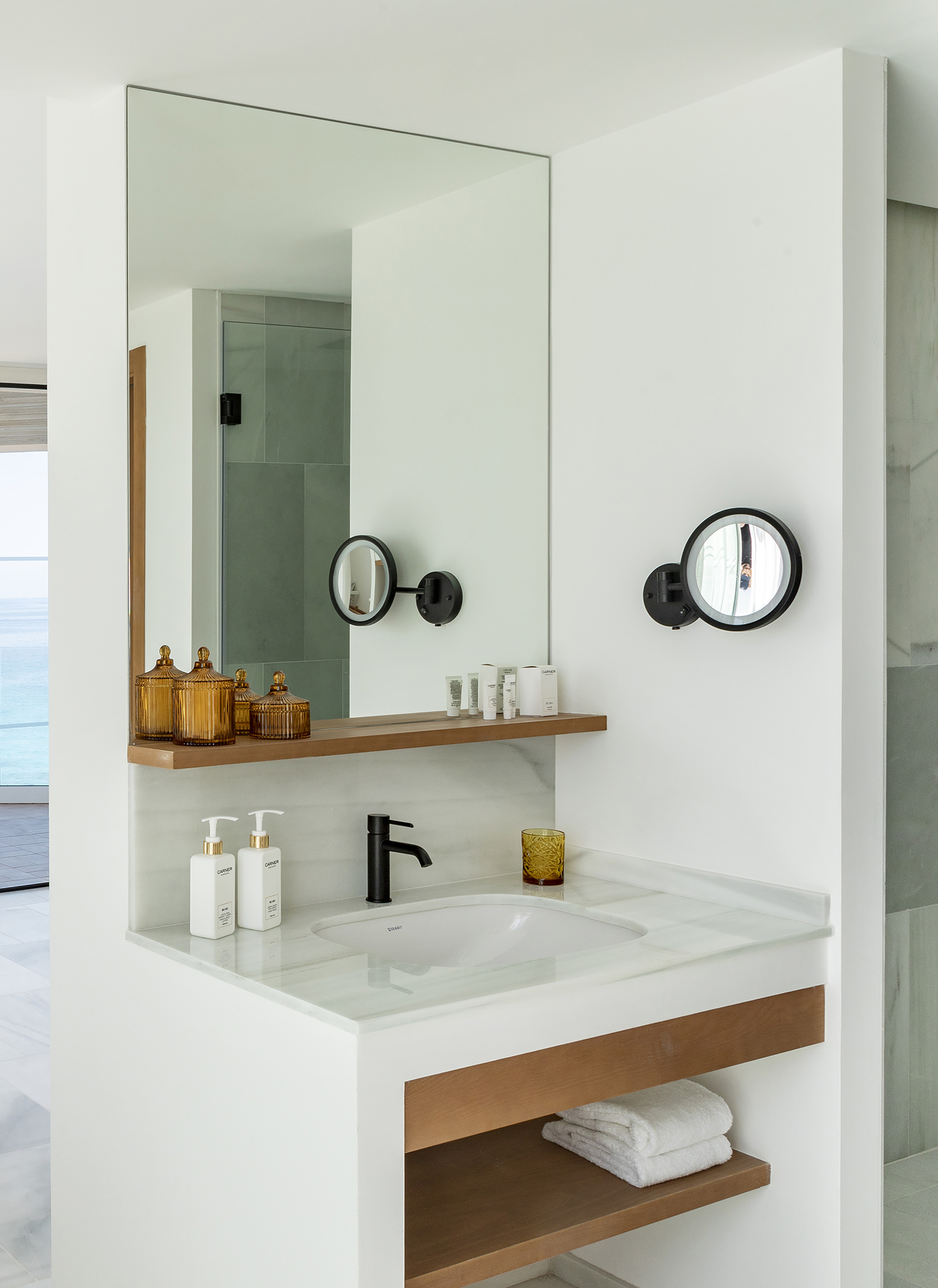 Luxury hotel bathroom vanity with modern design, white sink, and ocean view.