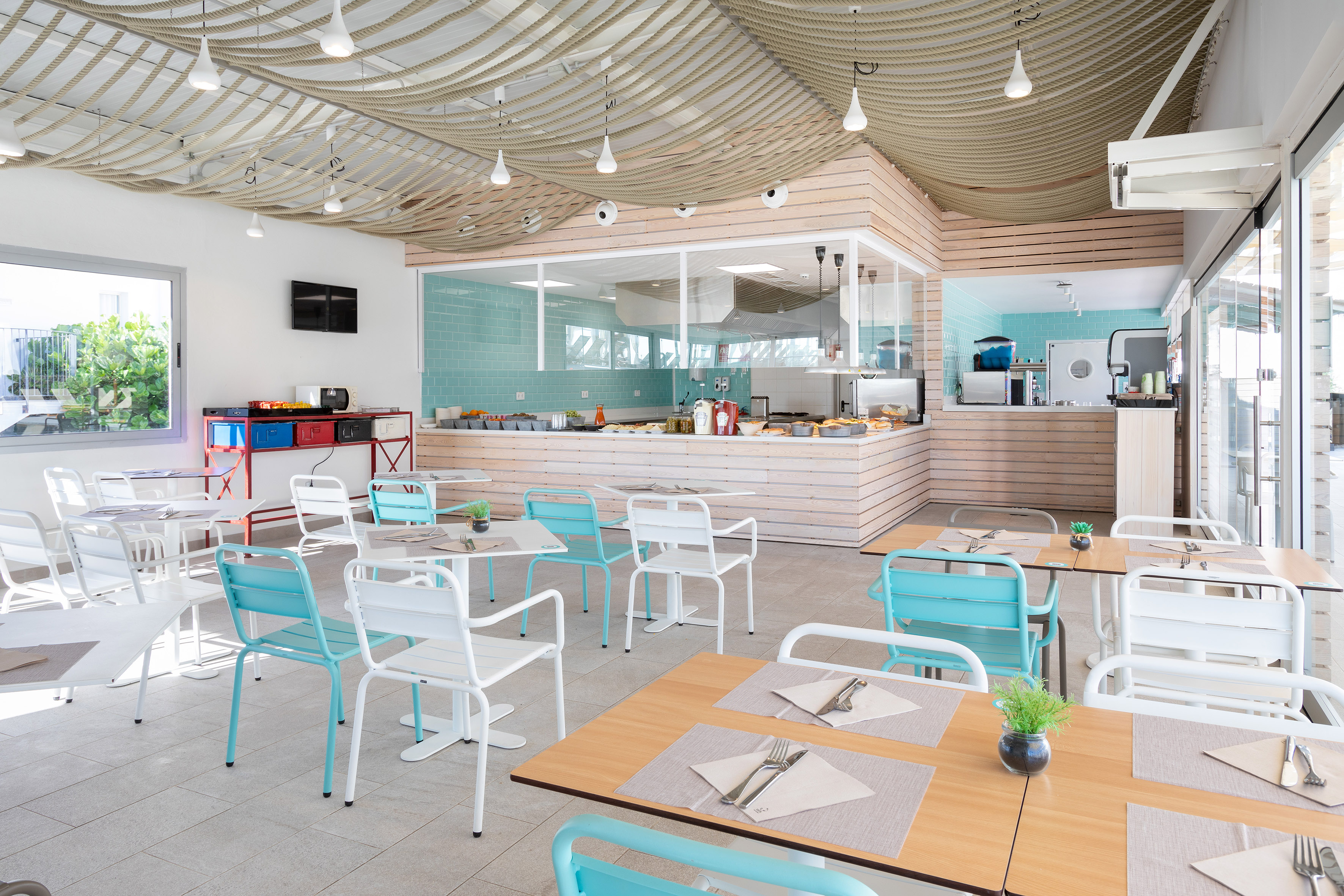 Hotel buffet restaurant with light wood and turquoise accents, unique rope ceiling.