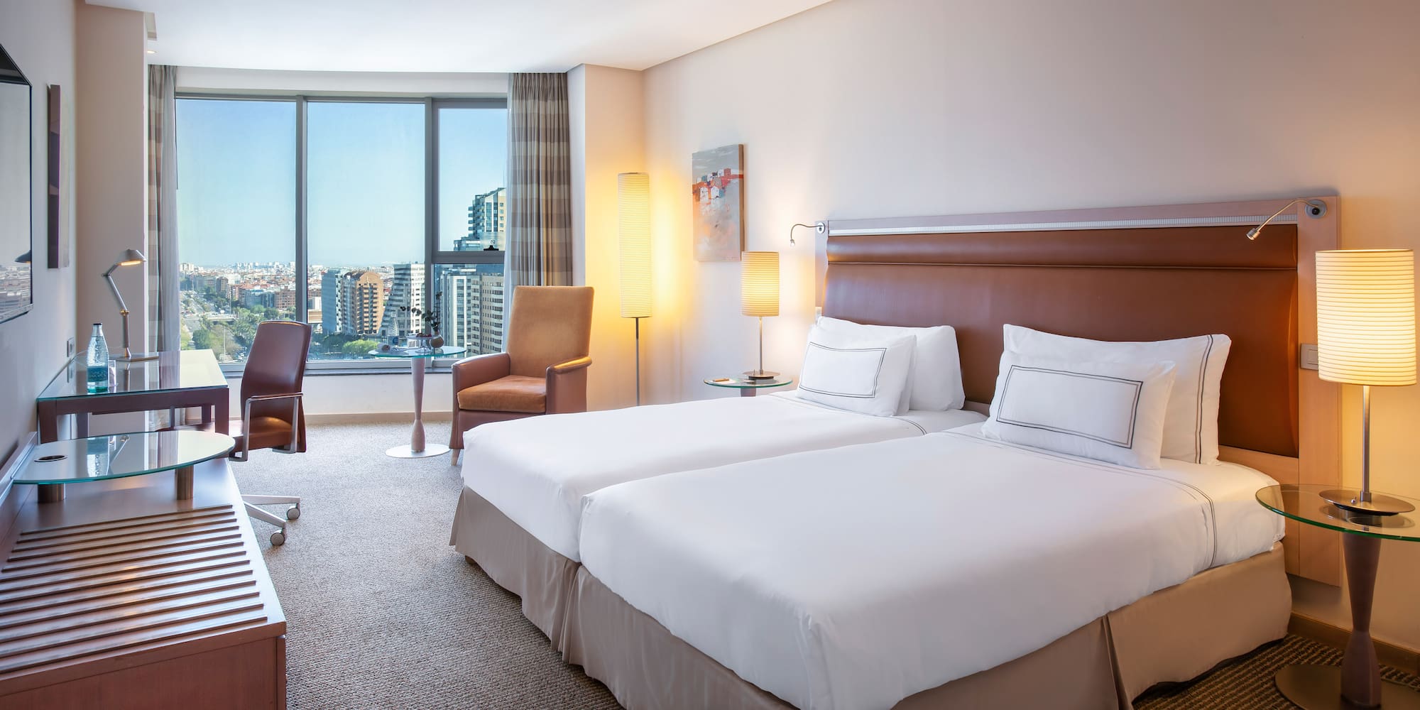 a hotel room with two beds and a large window