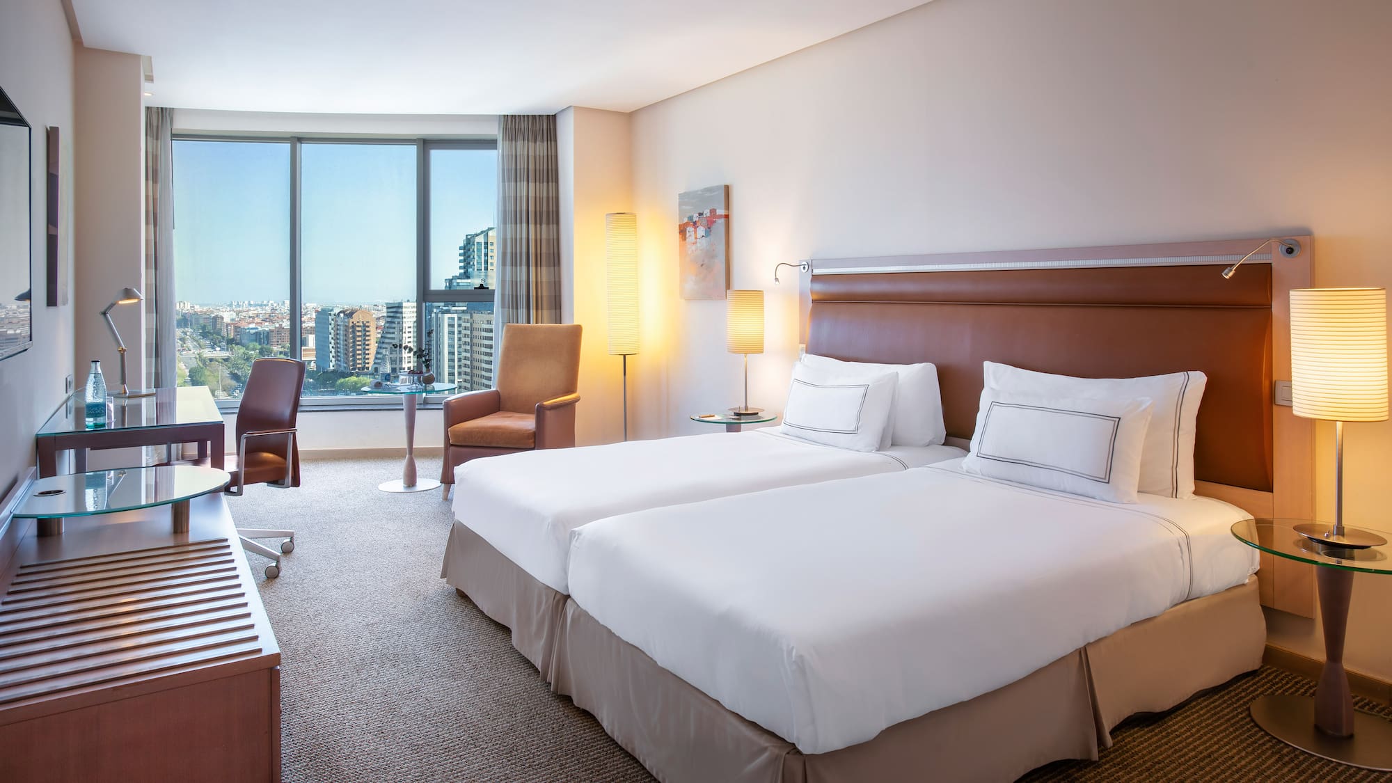 a hotel room with two beds and a large window