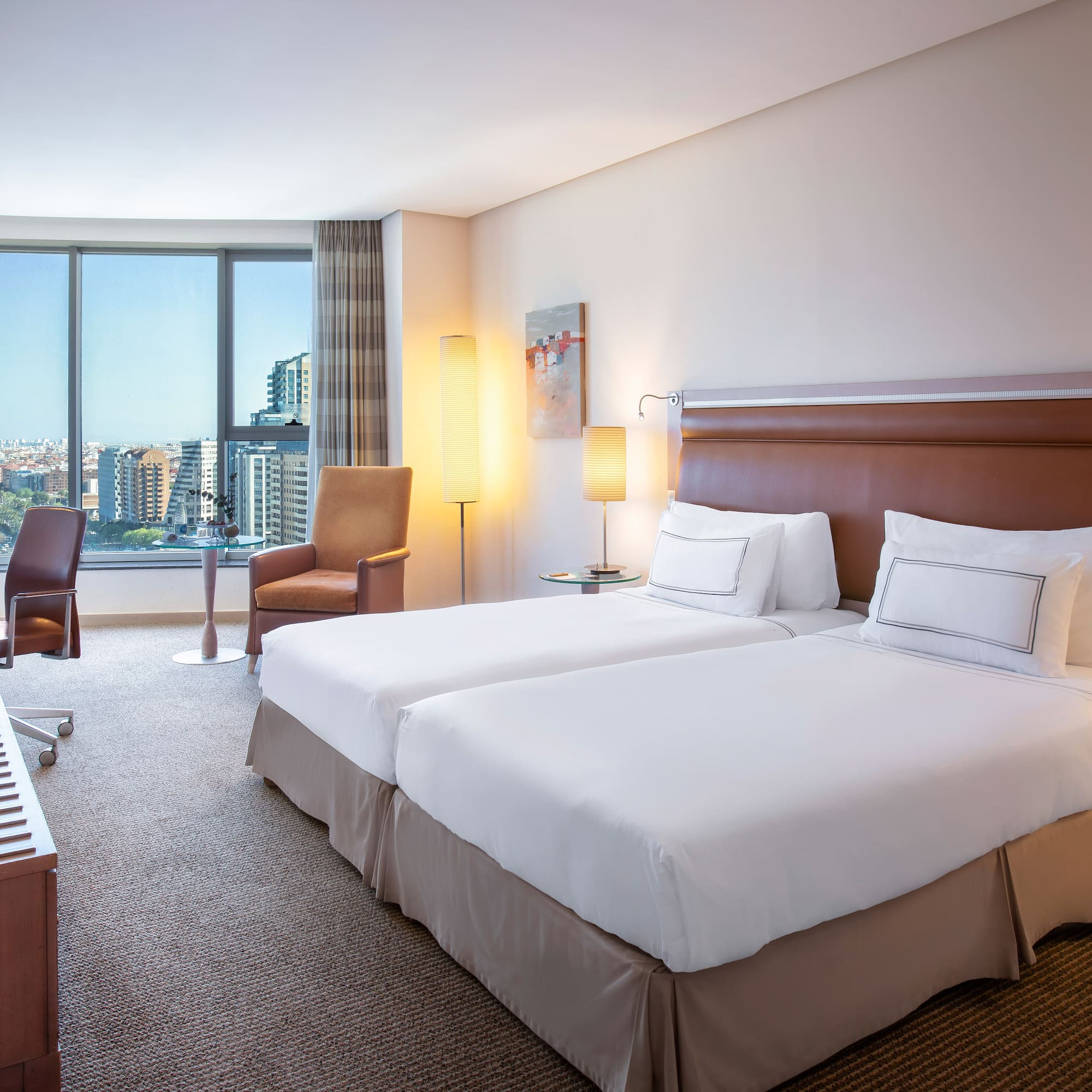 a hotel room with two beds and a large window