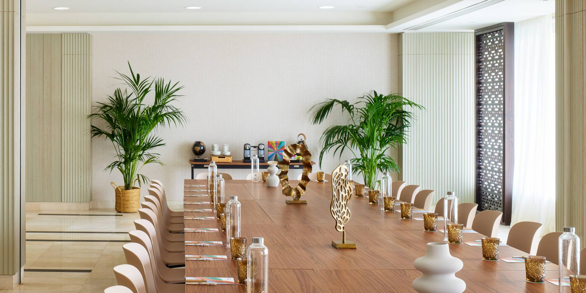 a long table with chairs and vases on it