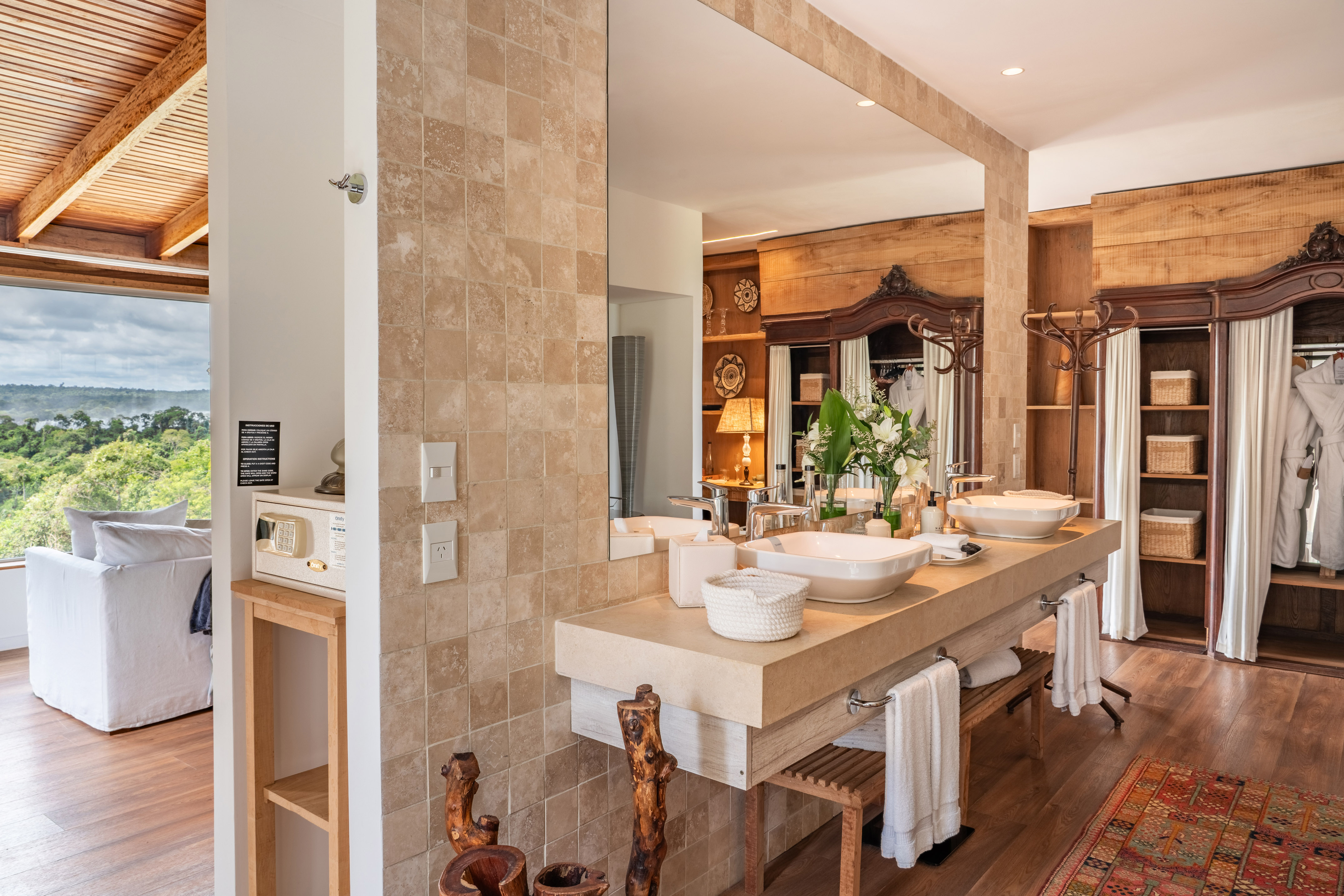 Hotel bathroom double vanity, natural wood, stone tiles, jungle view.