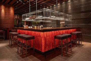 a bar with a red counter and chairs
