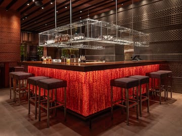 a bar with a red counter and chairs