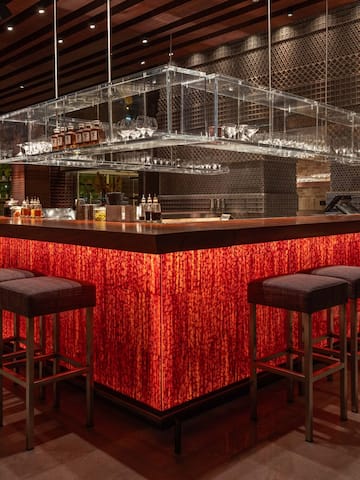 a bar with a red counter and chairs