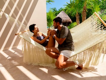 a man and woman sitting in a hammock