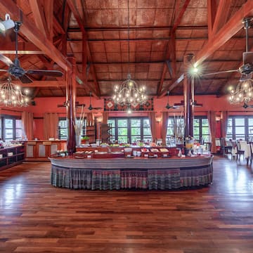 a large room with a large round table and ceiling fans