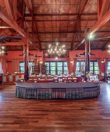a large room with a large round table and ceiling fans
