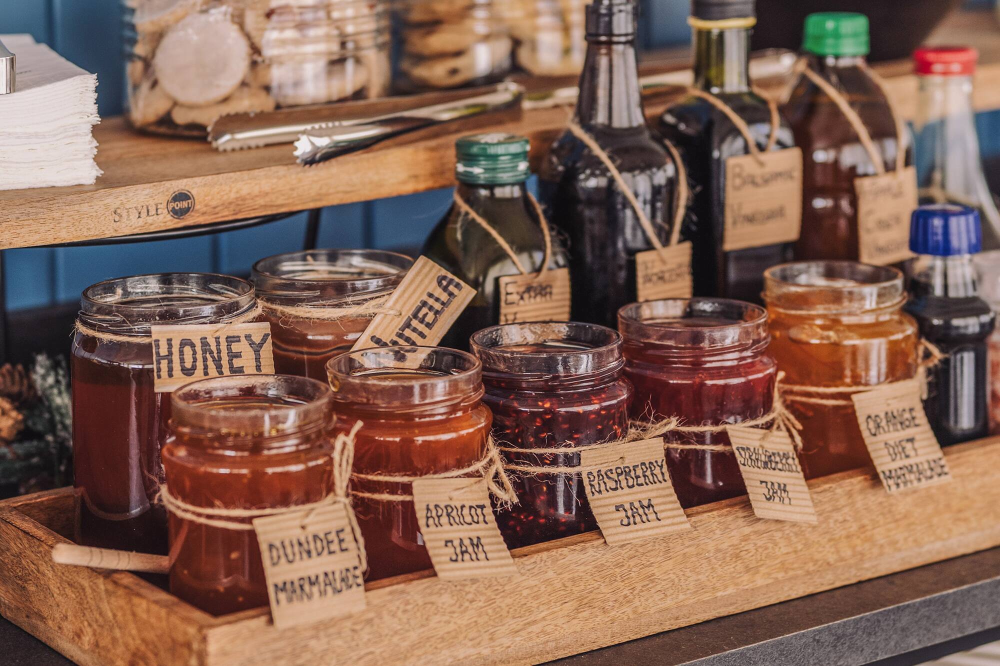 Breakfast display with honey, Nutella, fruit jams, marmalades, and cookies.
