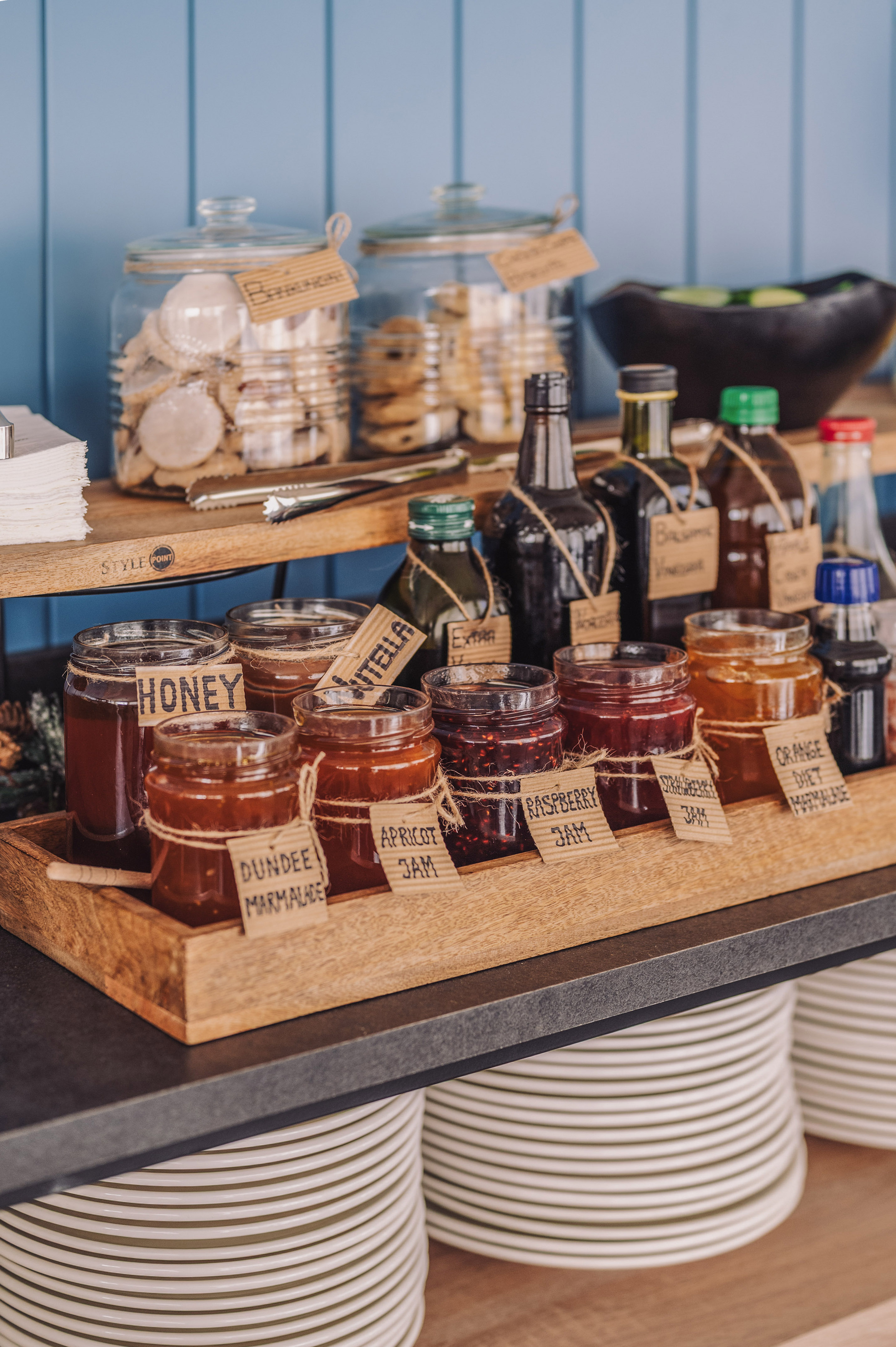 Breakfast display with honey, Nutella, fruit jams, marmalades, and cookies.