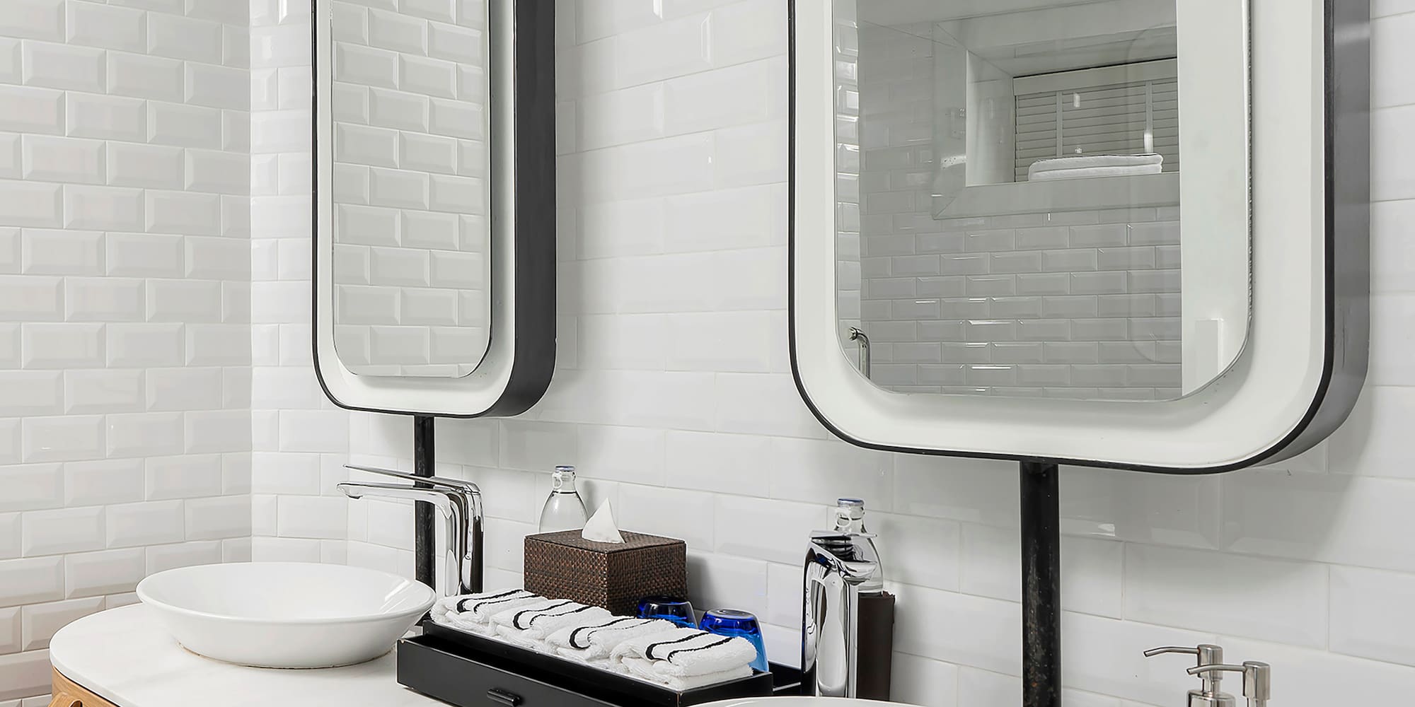 a bathroom with a double sink and two mirrors