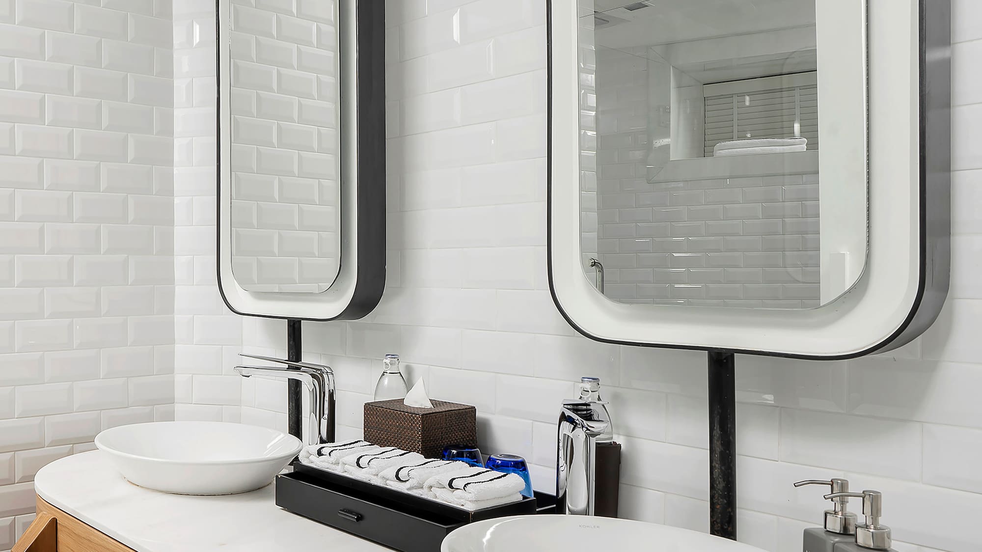 a bathroom with a double sink and two mirrors