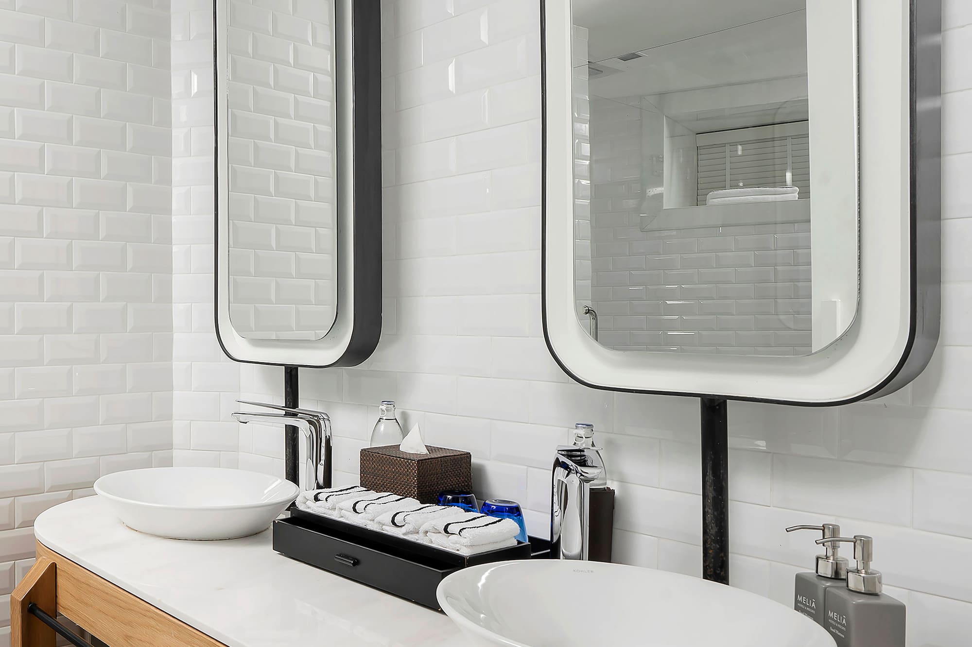 a bathroom with a double sink and two mirrors